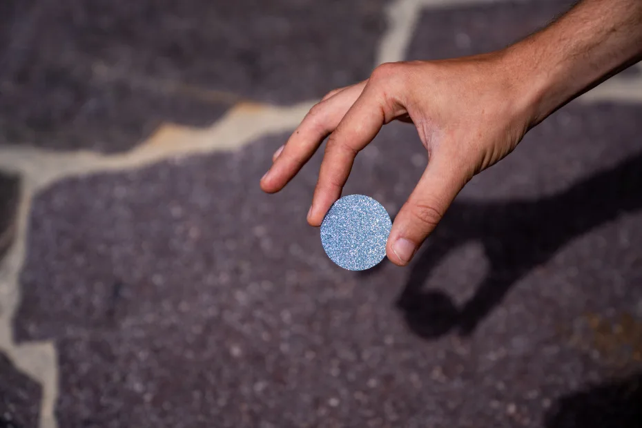 An osmium investment disc held in the hand